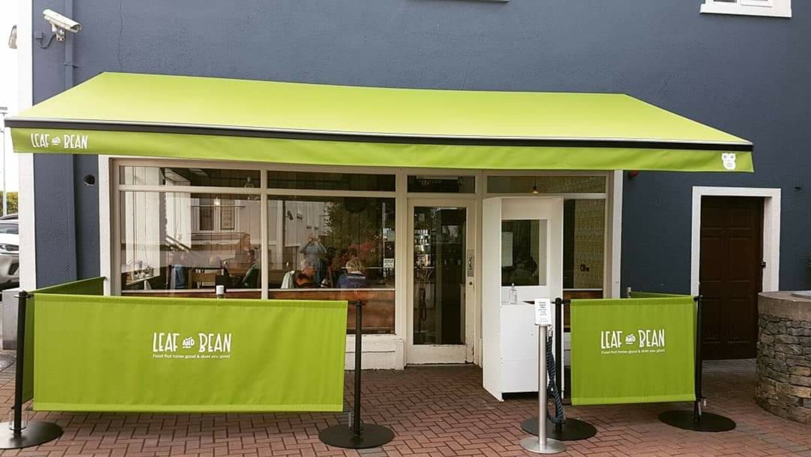 The Leaf and Bean shopfront on Bishop Street, Tuam: a lime green awning over the window, on a slate blue wall.
